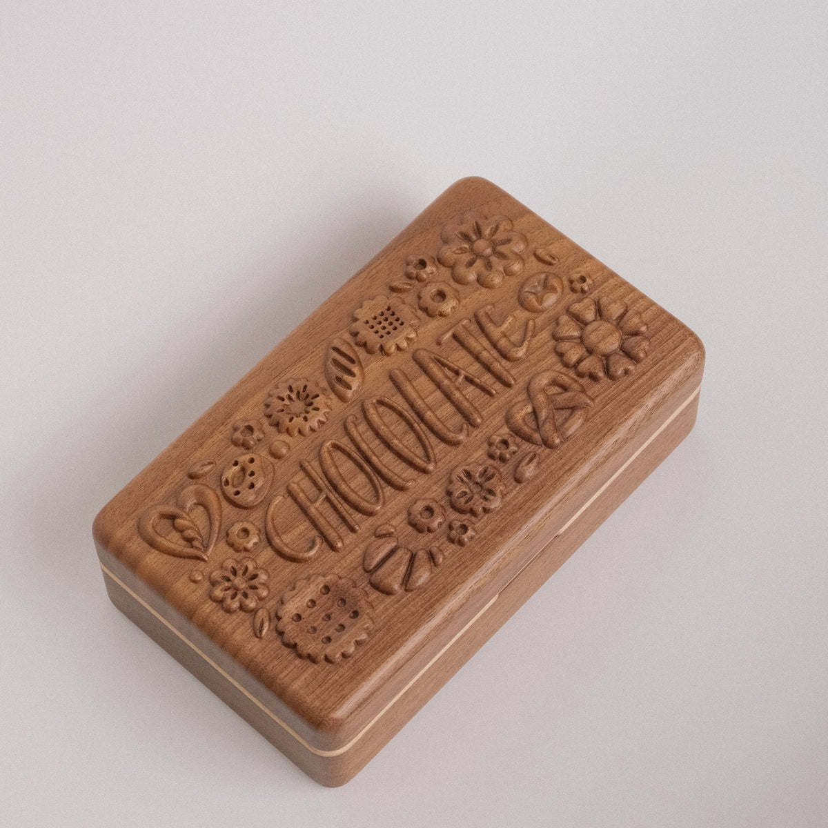 Closed Coco walnut jewelry box with carved chocolate design