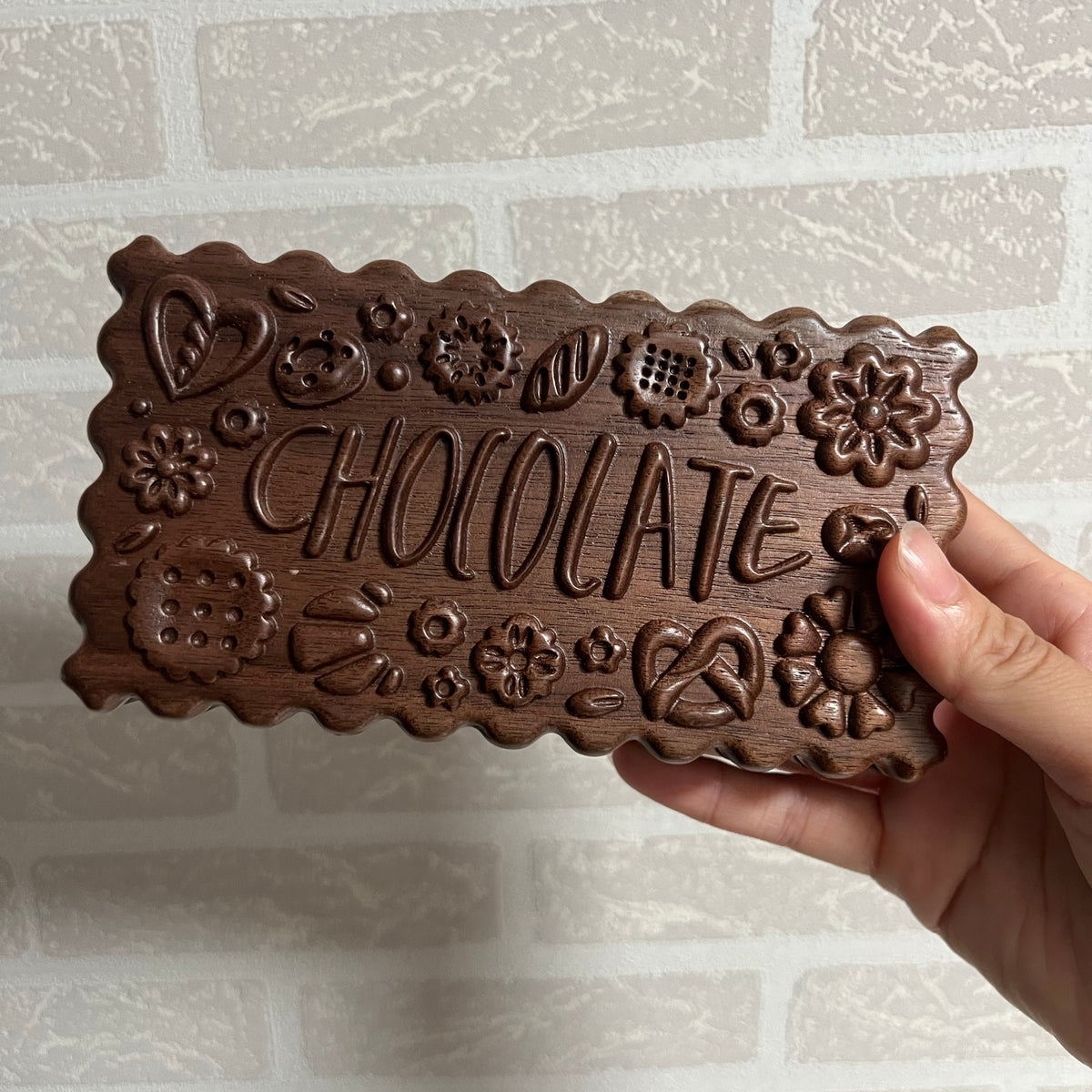 Hand holding the carved Cokkie palette lid