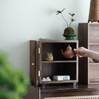 Open Agni walnut storage cabinet displaying tea ware and decorative objects