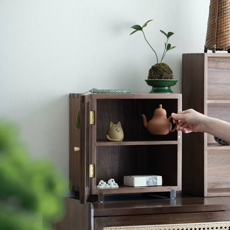 Open Agni walnut storage cabinet displaying tea ware and decorative objects