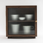 Front view of the Agni walnut cabinet with fluted glass door