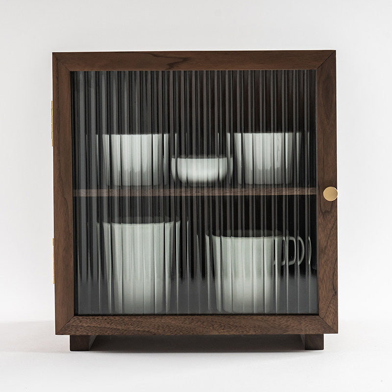 Front view of the Agni walnut cabinet with fluted glass door