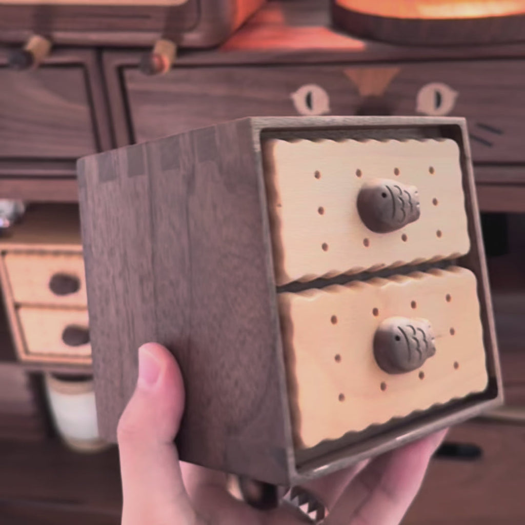 Hand holding the Oudine two-drawer cabinet