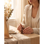 Walnut ring cone holder on tabletop with gold-tone ring being placed by hands