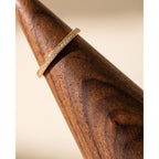 Close-up walnut ring cone holder with gold-tone band and sparkling stone detail