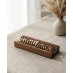 Walnut ring slot wooden holder showing multiple stacked rings in long front channel