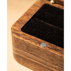 Close-up of the internal magnet on the inner rim of a walnut ring box, black velvet interior