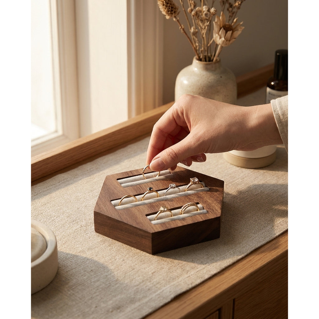 Walnut hexagon ring holder with three velvet slots; hand places a ring