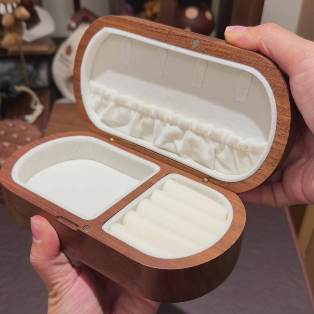 Hands holding an empty open Lisse black walnut portable jewelry box